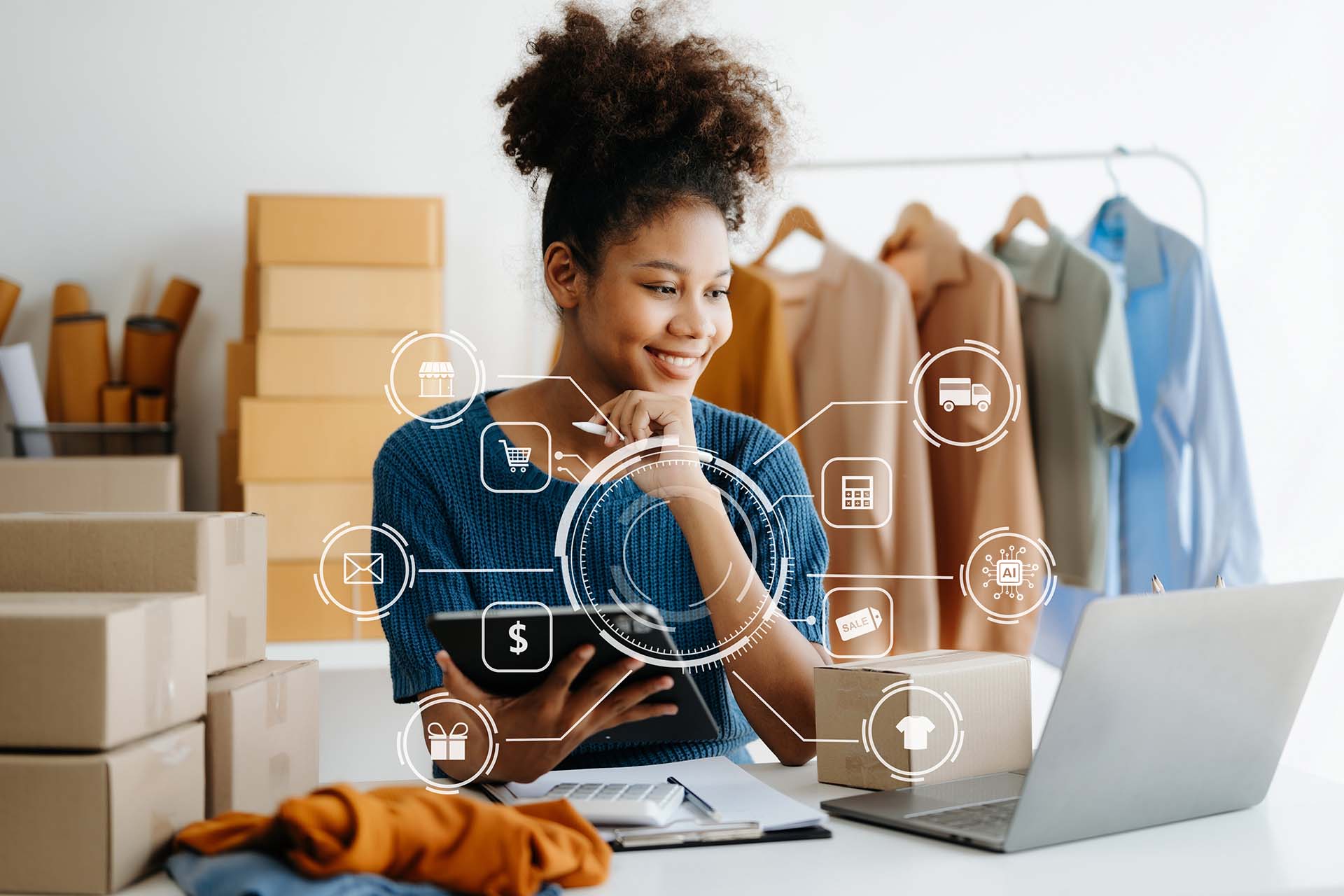 Hymyilevä nainen katsoo tietokonettaan ympärillään verkkokaupan tuotteita, etualalla verkokkauppaan liittyviä ikoneita