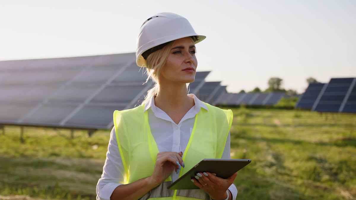 Engineer woman with tablet front of solar panels