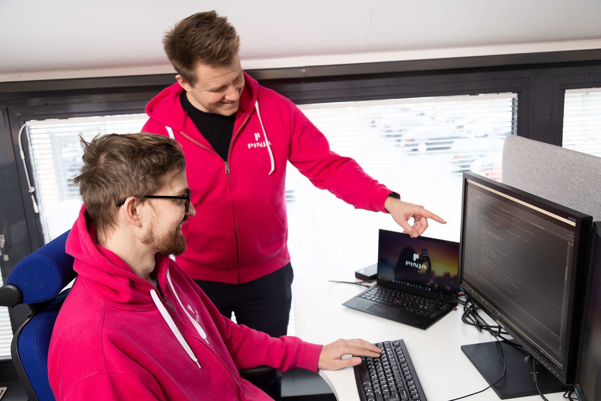 Pinja's software developers pair coding on a computer